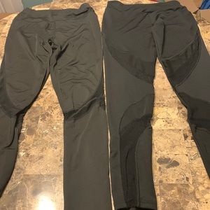 Two black workout leggings with mesh sheer panels
